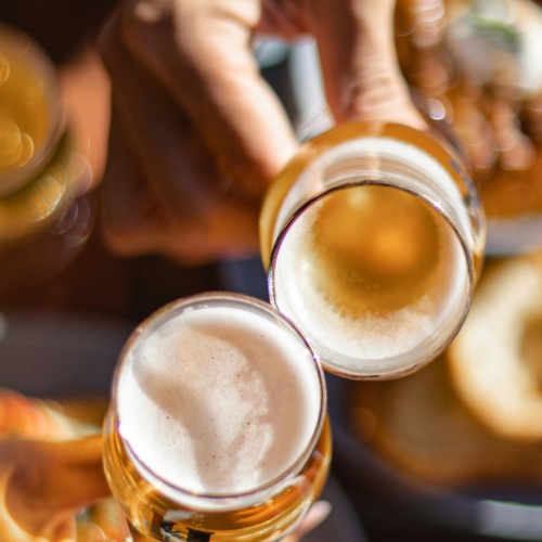 a group of people holding glasses of beer