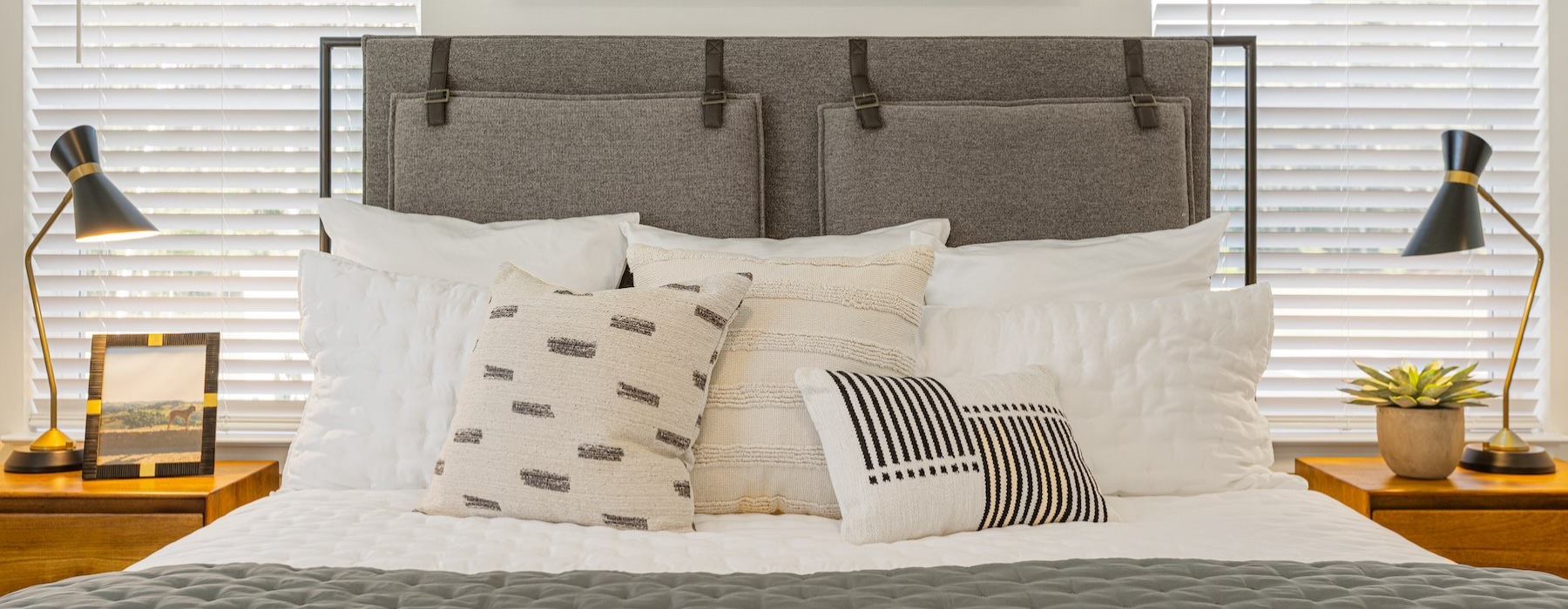 a bed with pillows and lamps