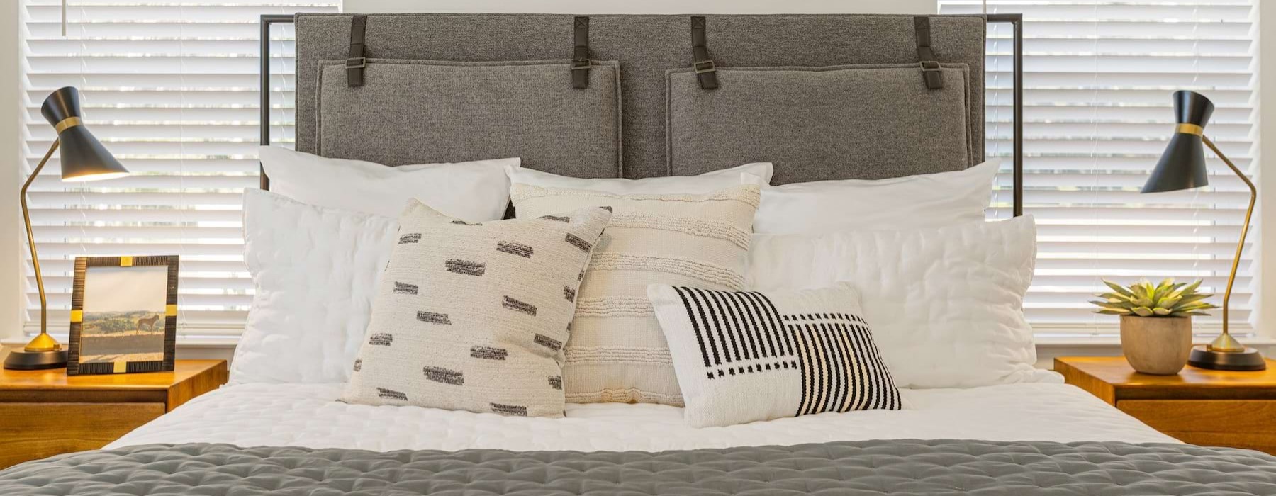 a bed with pillows and lamps
